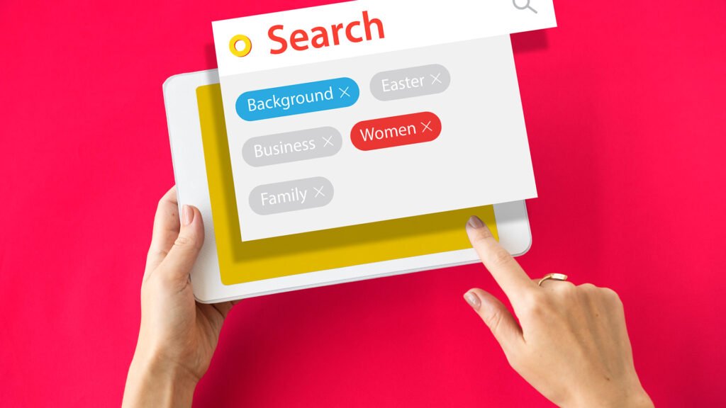 Hands using tablet with digital search tags and keyword filters representing SEO keyword research, search optimization, and online marketing strategy.