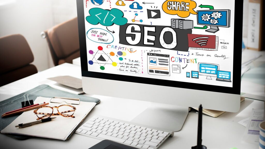 Computer screen showing SEO search engine optimization graphics on office desk, representing digital marketing strategy and website ranking improvement