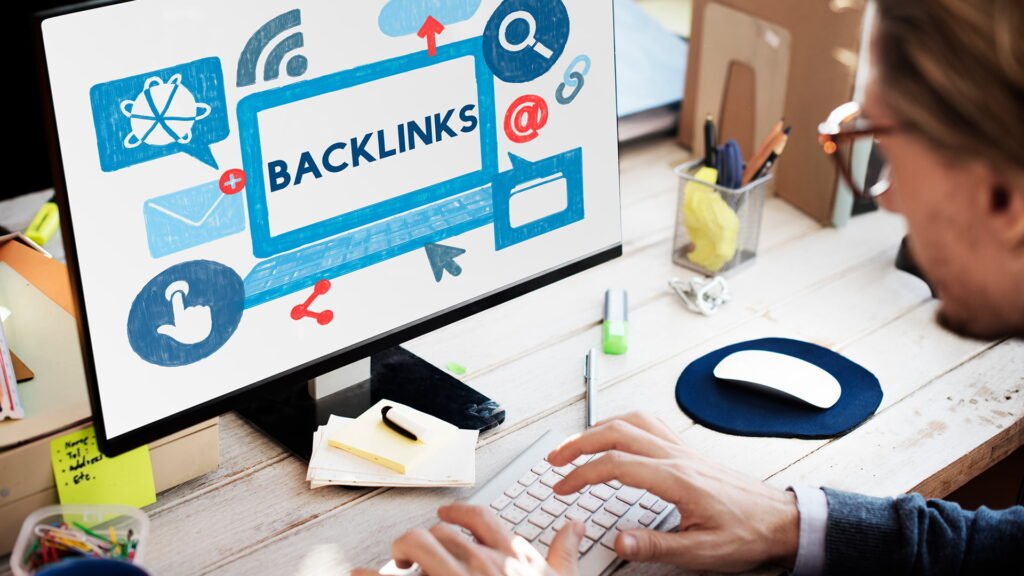 Person working on computer displaying backlinks concept on screen, representing backlink building strategy and SEO link building
