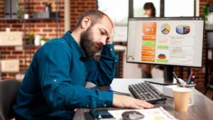 Business owner looking frustrated while reviewing website analytics on a computer, illustrating common SEO mistakes that reduce search rankings and organic traffic.