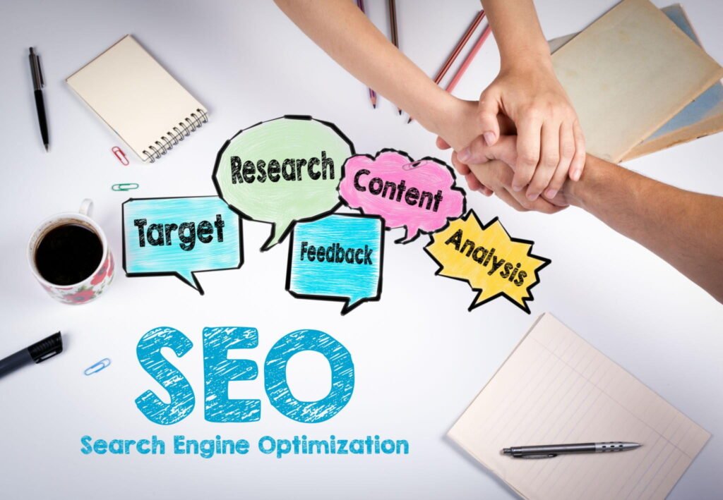 SEO concept image showing search engine optimization icons with target audience analysis, content strategy, keyword research, feedback, and digital marketing elements on a workspace table.