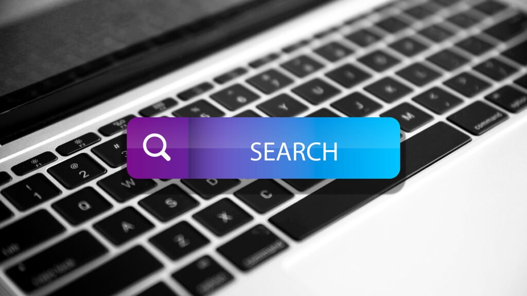 Close-up of a laptop keyboard with a digital search bar icon, representing Google search, SEO strategy, keyword research, and website ranking.