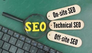SEO concept with magnifying glass highlighting SEO text and labels showing on-site SEO, technical SEO, and off-site SEO on a workspace desk