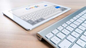 "Sleek tablet on Google search beside a silver wireless keyboard, styled on a light wooden desk — a modern digital workspace blending touch and precision